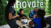 Young African businesswoman talking with a group of work colleagues during a meeting together around a table in an office boardroom